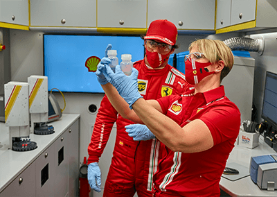 V-Power team looking at test tubes and testing renewable methods